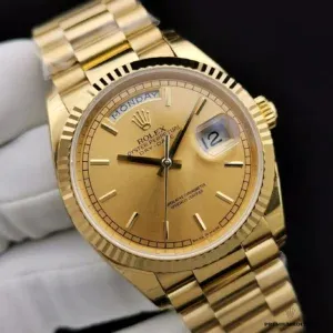 Wrist shot of gold dial Day-Date in indoor warm lighting