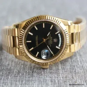 Angled shot showing yellow gold-plated fluted bezel and black dial contrast