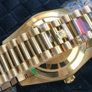 Full profile showing black dial against yellow gold-plated case