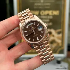 Close-up of chocolate dial with applied Roman numerals and day window