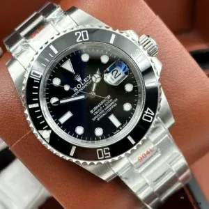 Black-dial Submariner 126610 on brown leather, red 904L protective stickers on the bracelet