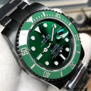 Close-up of green ceramic bezel insert with luminous pip at twelve