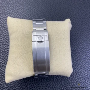 Glidelock clasp of a Submariner 116610LN from above, brushed links on a beige watch cushion