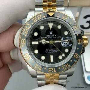Close-up of black dial with green GMT hand and luminescent markers