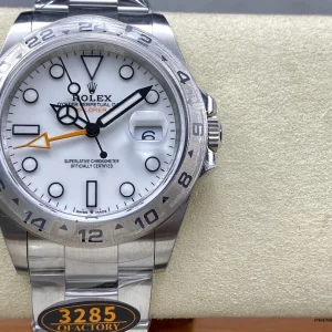 Close-up of white dial with orange 24-hour hand and date window