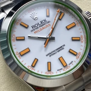 Close-up of white dial with orange accents and luminous indices