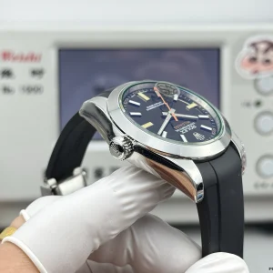 Black dial detail with green-tinted crystal and orange indices