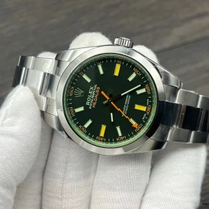 Rolex Milgauss 116400GV flat lay on dark surface with green crystal glow
