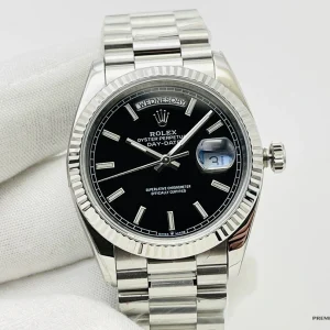 Close-up of black dial with platinum-tone stick hour markers