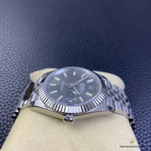 Close-up of grey dial surface and luminous baton markers