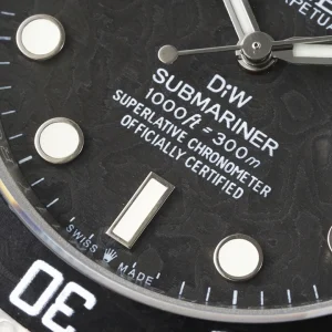 Carbon dial macro showing green luminous markers and date window at 3