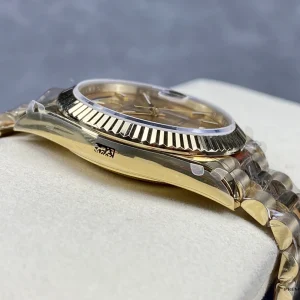 Close-up of champagne dial hour markers and day window