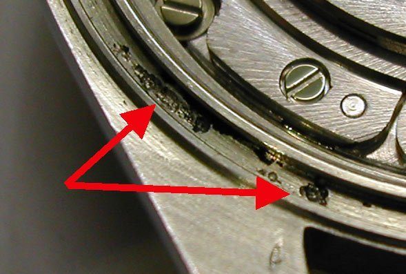 Corrosion pitting around watch caseback gasket area showing stainless steel degradation