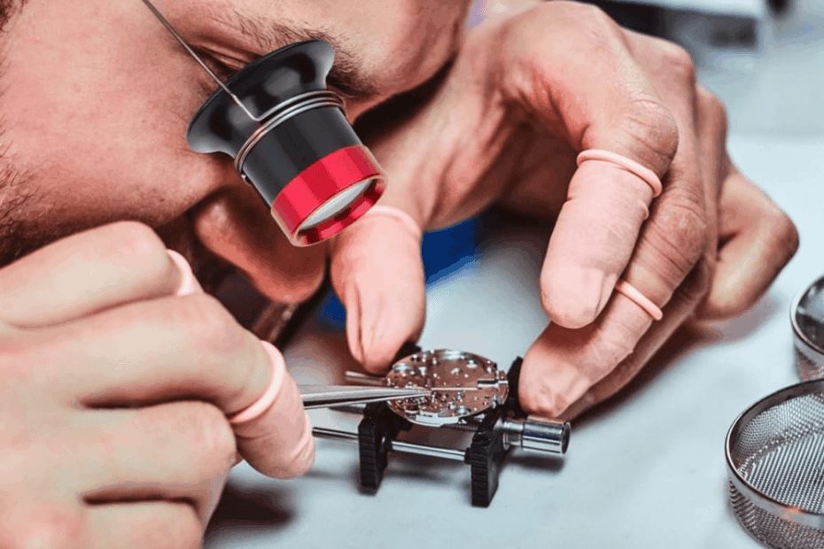 Watchmaker using loupe to inspect automatic watch movement at service bench