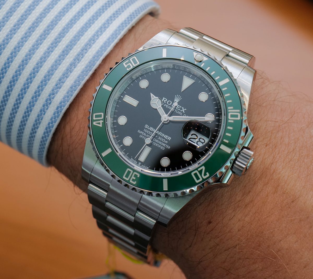 Rolex Submariner Kermit 126610LV green bezel on wrist with blue striped shirt